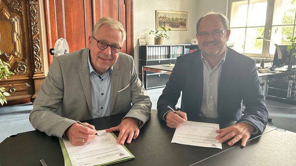 Vertragsunterzeichnung: Claudius Teske, Landrat des Kreis Steinburg (links) und Dr. Ingmar Soll von dataport.kommunal besiegeln den Betritt des Kreises zum DigitalHub Wilster